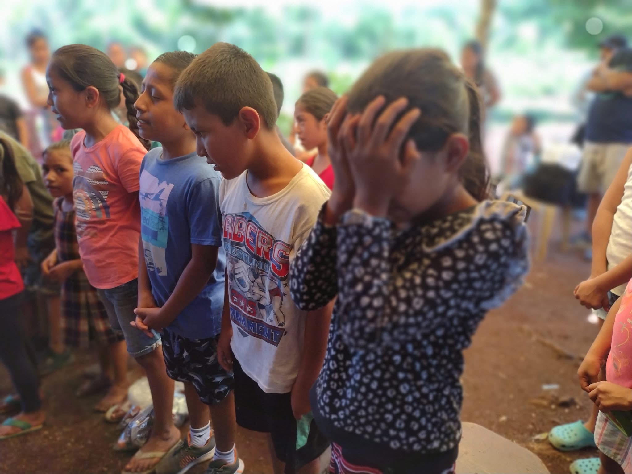 Children praying together in community