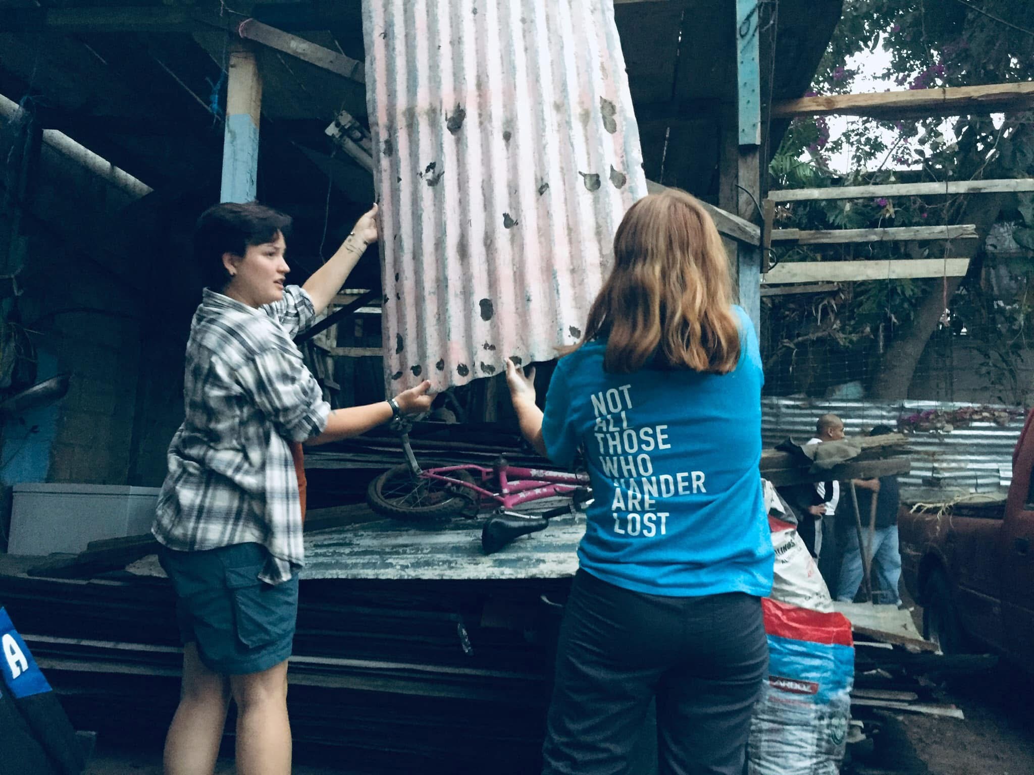 Volunteers serving a family by carrying materials